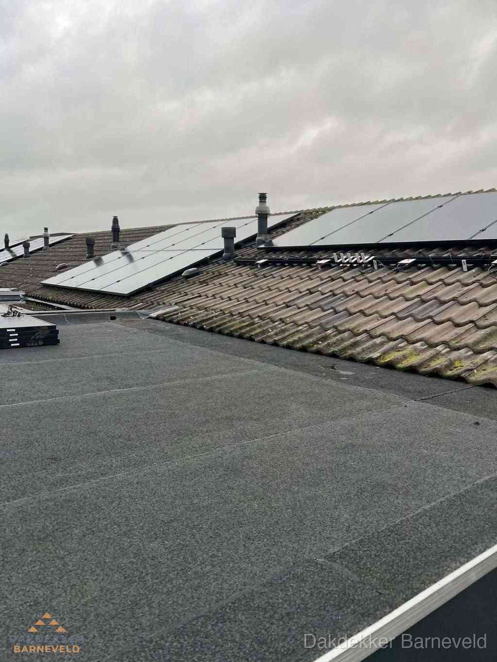 Plat dak inspectie met bitumen bedekking naast schuin pannendak in Barneveld