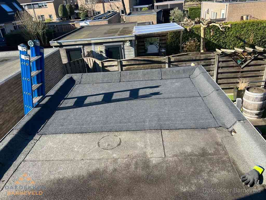 Dakdekker legt onderlaag op plat dak met houten constructie in Barneveld