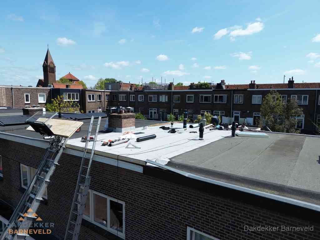 Dakdekkers aan het werk op plat dak in Barneveld