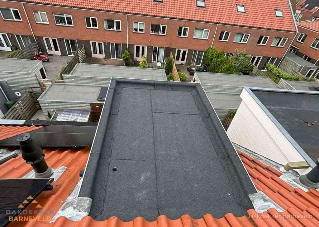 Plat dak met bitumen bedekking naast dakkapel in Barneveld
