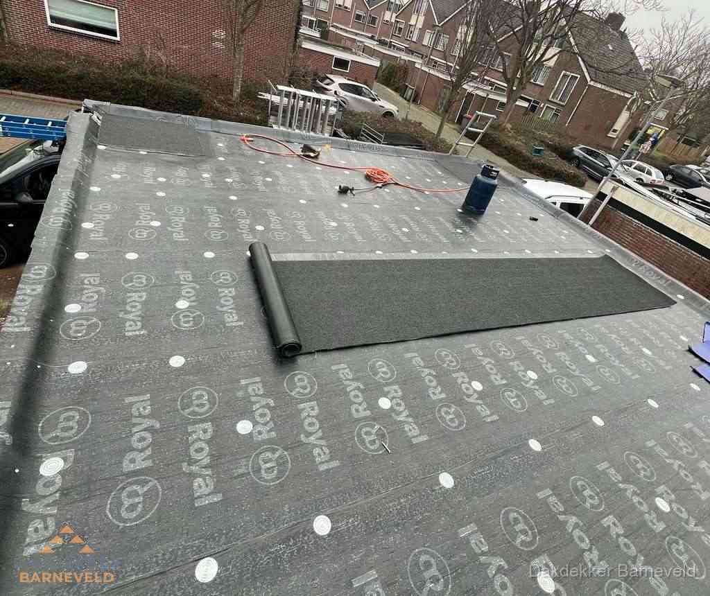 Dakdekker aan het werk met gasbrander op plat bitumen dak in Barneveld