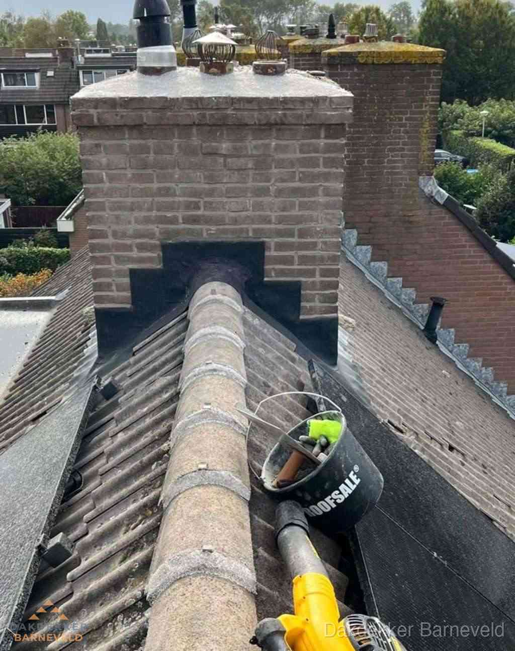 Dakdekker repareert bitumen dakleer bij dakdoorvoer in Barneveld
